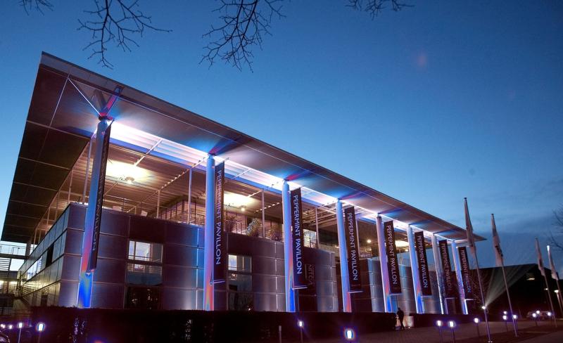 Peppermint Park Studios : stade avec des éclairages lumineux roses et bleus la nuit